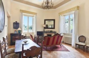 佛罗伦萨3bdrm luxury Apartment in Tuscan Villa,Private Estate, shared Swimmingpool的客厅配有桌椅和窗户。