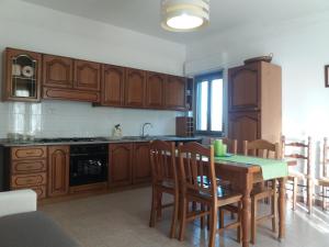 莫塔卡玛斯特拉Casa Fronte Gole Alcantara的厨房配有木制橱柜和桌椅