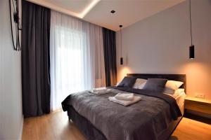 热舒夫Premium Apartments Rzeszów的一间卧室配有一张大床和两条毛巾