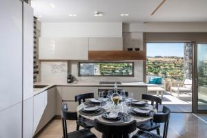 库基尼坎尼奥Kymo Instyle Villa - Sea view Private pool Jacuzzi的厨房以及带桌椅的用餐室。