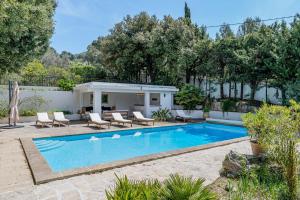 卡西斯Domaine Maraspar Cassis的一个带椅子的庭院和房子的游泳池