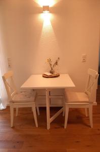 BalveWaldurlaub Klingelborn im Sauerland的一张桌子和两把椅子,配有白色的桌子和灯