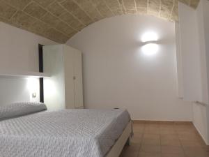 乌真托Ugento Dimora的卧室配有白色的床和白色的墙壁