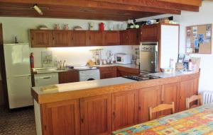 邓莫尔东Wreckers Cottage的厨房配有木制橱柜和白色冰箱。
