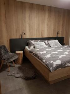诺瓦佩奇Apartmán Pod Hochfichtem的一间卧室设有一张床和木墙