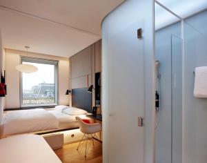 哥本哈根citizenM Copenhagen Radhuspladsen的一间卧室配有一张床、一张书桌和一个窗户。