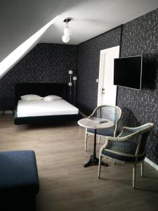 科克赛德B&B VILLA MONIQUE的卧室配有一张床和一张桌子及椅子