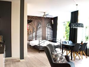 米德尔堡ApartHotel Waepen van Middelburg的卧室配有一张床和一张桌子及椅子