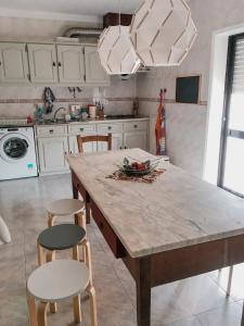 富拉多鲁Casa do gato branco的厨房配有大型木桌和椅子