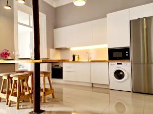 塔维拉Casa Lara by HnM的厨房配有白色橱柜、桌子和洗碗机。