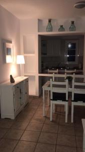 塞博河畔卡莱塔Apartamentos Burgao的一间带桌椅的客厅和一间厨房