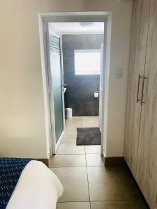 布隆方丹Impa-Lala Country Estate的一间卧室设有一扇门,可通往一间带一张床的浴室