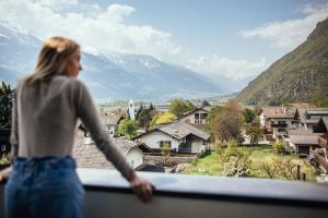 拉布拉Hotel Rablanderhof的站在一个眺望着山脉的阳台上的女人