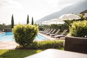 卡斯泰尔贝洛Hotel Bauhof的游泳池旁设有躺椅和遮阳伞