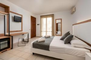 圣维托罗卡波置身天堂酒店的一间卧室配有一张床、一张书桌和一台电视
