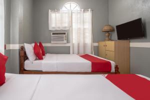 安蒂波洛OYO 588 Sunrock Resort的一间卧室配有两张床和电视。