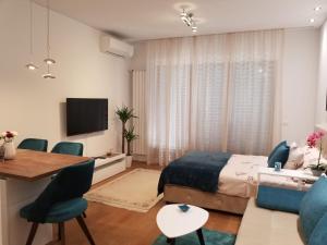 贝尔格莱德Azura Residence - new luxury apartment的卧室配有一张床和一张桌子及椅子
