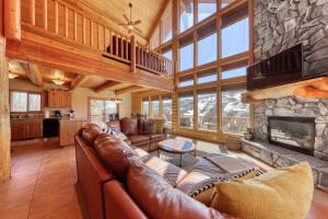 布赖恩峰Ski-View Lodge的客厅配有皮革家具和石制壁炉