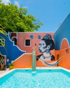 普拉亚卡门卡萨代拉斯弗洛雷斯酒店的一座游泳池,在建筑物的一侧画着画
