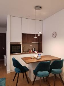贝尔格莱德Azura Residence - new luxury apartment的厨房配有木桌和蓝色椅子