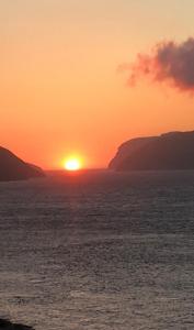 SandavágurThe Atlantic view guest house, Sandavagur, Faroe Islands的远方的太阳在海上的日落