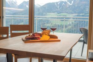 MaretaJaufnerhof的一张桌子,上面放着一盘食物和两杯葡萄酒