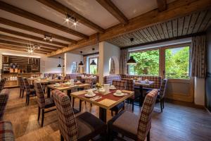 比绍夫斯维森布瑞奈巴斯彻特艾尔潘酒店的用餐室配有木桌和椅子