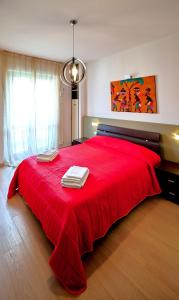 米兰Farini Apartment的一间卧室配有红色的床和毛巾
