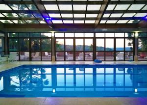 格拉玛多Sky Borges Hotel Alpenhaus - Gramado的一座带大窗户的建筑中的游泳池