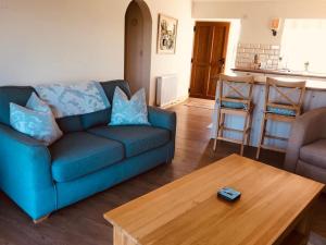 比代尔Little welham的客厅配有蓝色的沙发和木桌