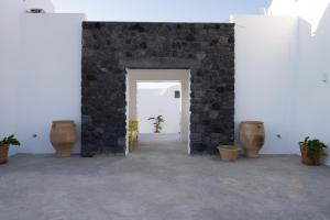 伊亚Oia Kissiri - private pool villas的一间设有石墙和花瓶的房间