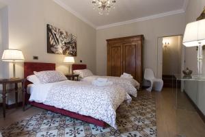 坎波巴索B&B Palazzo de I Mysteri的一间卧室配有两张床和吊灯。
