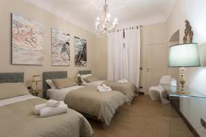 坎波巴索B&B Palazzo de I Mysteri的带三张床和吊灯的客房