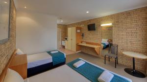 查尔维尔Mulga Country Motor Inn的客房设有带一张床和一张书桌的卧室。