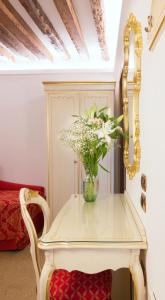 威尼斯莱奥纳多酒店的一张白色的桌子,上面有花瓶