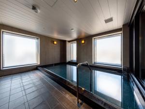 大阪Granbell Hotel Osaka的一个带两个窗户的房间的游泳池