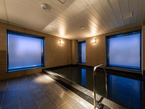 大阪Granbell Hotel Osaka的一座带两个大窗户的游泳池