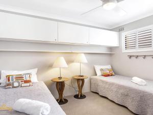 浅滩湾Bay Village No 7 Shoal Bay的一间卧室设有两张床和窗户。