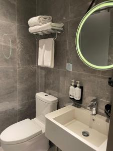 北京北京遨途机场酒店的一间带卫生间、水槽和镜子的浴室