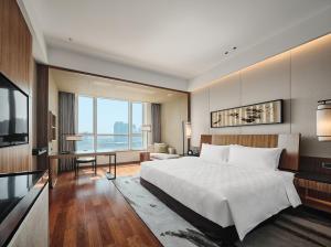 宁波宁波港城华邑酒店的一间卧室设有一张大床和一个大窗户