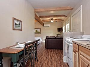 温伯利Cabins at Flite Acres-Mockingbird Cabin的厨房以及带桌椅的起居室。