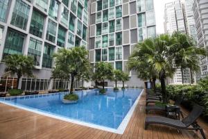 吉隆坡Soho Suites KLCC By iRent365的一座大型建筑,设有一座棕榈树大型游泳池