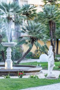 比萨The Rif - Boutique Hotel的棕榈树公园内一座带雕像的喷泉