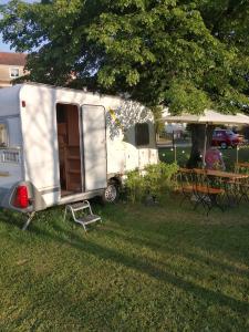 皮尔纳"Campingplatz Altjessen 57"的白色拖车、桌子和帐篷