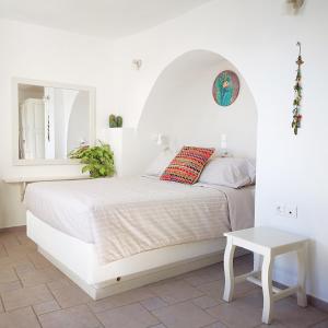 易莫洛林Spitia Tzitzi的白色卧室配有床和桌子