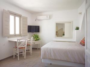 易莫洛林Spitia Tzitzi的一间卧室配有一张床、一张书桌和一面镜子