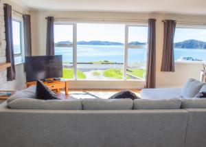 派西亚Rehutai Beach House的带沙发和大窗户的客厅