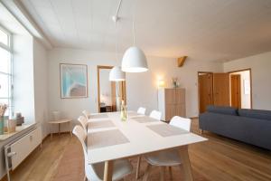 森讷堡Exclusive 2 Bedroom Apartment的用餐室以及带白色桌椅的起居室。