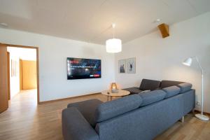森讷堡Exclusive 2 Bedroom Apartment的客厅配有蓝色的沙发和桌子