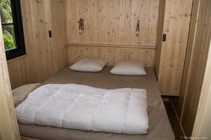 Moncrabeau乐穆利阿特露营地的木制客房内的一间卧室配有两张床